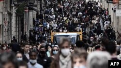 People walk in a crowded shopping street in Bordeaux on May 19, 2021, as cafes, restaurants and other businesses re-opened after closures during the COVID-19 pandemic.