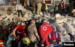 Tim penyelamat mencari korban selamat di lokasi bangunan yang rusak, pasca gempa mematikan, di Kota Jableh, Suriah, 10 Februari 2023. (Foto: REUTERS/Yamam al Shaar)