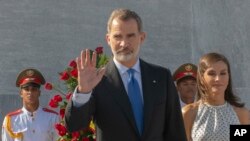 FILE - Spain's King Felipe VI waves as Queen Letizia walks with him in Havana, Cuba, Nov. 12, 2019.