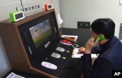 In this photo provided by South Korea Unification Ministry, a South Korean government official communicates with a North Korean officer during a phone call on the dedicated communications hotline at the border village of Panmunjom in Paju, South Korea.