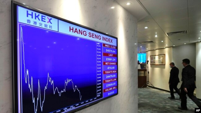 A screen displays the Hong Kong share index at the Hong Kong Stock Exchange on Oct. 4, 2021. Shares in troubled real estate developer China Evergrande Group and its property management unit Evergrande Property Services were suspended from trading Monday i