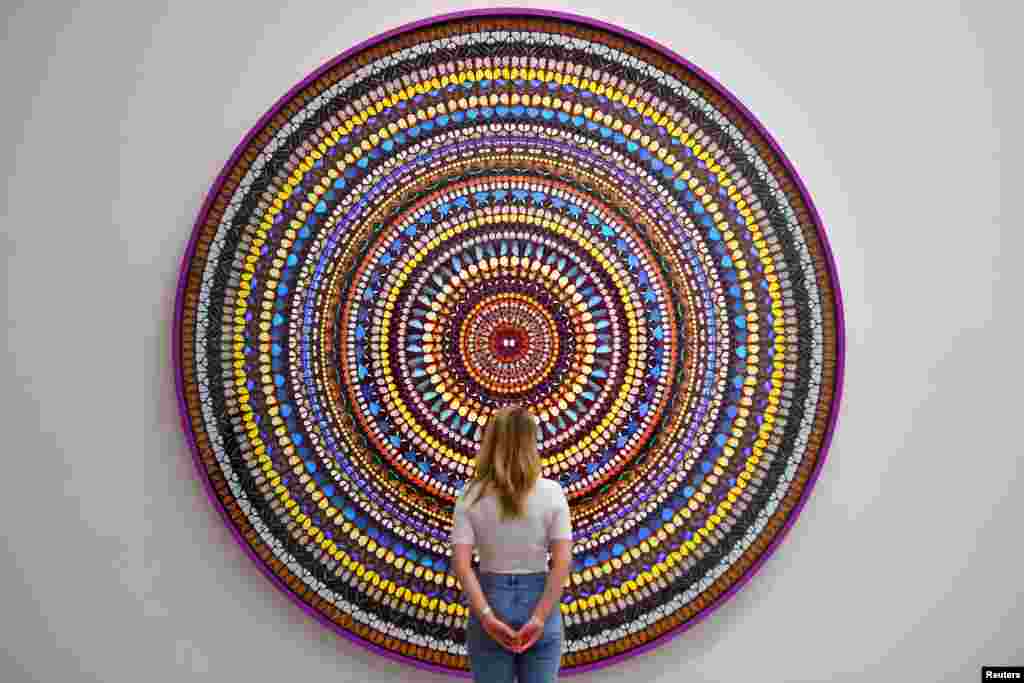 A gallery assistant stands in front of &quot;Deity&quot; by Damien Hirst during an exhibition of his new work entitled &quot;Mandalas&#39; at the White Cube in London.