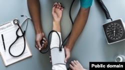 A nurse uses a blood pressure machine to examine a patient.