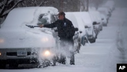 Čovek čisti sneg sa automobila u Vašington aveniji u Ronoku, Virdžinija, 9. decembra 2018.