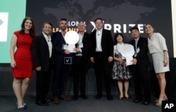 Representatives from onebillion, Jamie Stuart, third from left, and Andrew Ashe, fourth from left, and representatives from KitKit School, Sooinn Lee, third from right, and Gunho Lee, second from right, receive the XPRIZE Children's Literacy award.