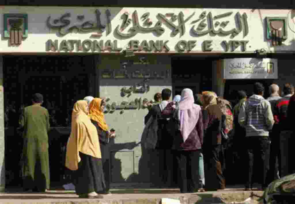 Un grupo de egipcios esperan ante un cajero automático para retirar efectivo.