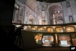 Images of St. Peter's Basilca are projected on a screen during a press exhibition 'Petros eni', which is part of the project "St. Peter's Basilica: AI-Enhanced Experience" at the Vatican, Saturday, Nov. 9, 2024. (AP Photo/Gregorio Borgia)