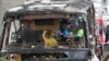 Officers of a police forensics team inspect a bus that caught fire, carrying young students with their teachers, in suburban Bangkok, Oct. 1, 2024.