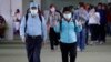 A passenger wearing a mask gestures as they arrive at Manila's international airport, Philippines, Thursday, Jan. 23, 2020.