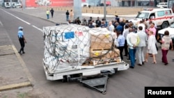 FILE - Officials stand near mpox vaccines as first batches from Europe arrive at N'Djili International Airport in Kinshasa, Democratic Republic of Congo, Sept. 5, 2024. DRC officials said the first doses from the United States arrived on Sept. 10, 2024.