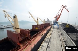 A cargo ship is loaded with coal during the opening ceremony of a new dock at the North Korean port of Rajin, July 18, 2014.