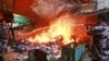 Members of the Palestinian Civil Defense hose down a shop that caught on fire due to clashes between Palestinians and Israeli soldiers in the West Bank city of Jenin, June 19, 2014.