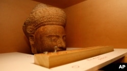 The 10th-century Cambodian sandstone statue form the Metropolitan Museum of Art in New York is seen in a box during a handover ceremony, at Phnom Penh International Airport, Phnom Penh, Cambodia, Tuesday, June 11, 2013.