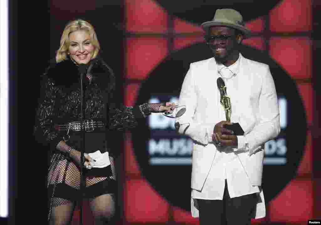 Singer Madonna accepts the award for "Top Touring Artist" presented to her by musician Will.i.am (R), during the Billboard Music Awards at the MGM Grand Garden Arena in Las Vegas, Nevada May 19, 2013. REUTERS/Steve Marcus (UNITED STATES - Tags: ENTERTAINM