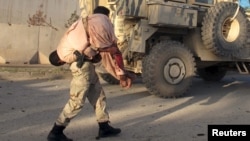 سرباز افغان یکی از مجروحان را منتقل می کند. 