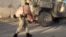 FILE - An Afghan security personnel carries a wounded man after a suicide car bomb blast attacked a military convoy in Lashkar Gah, Helmand province, Afghanistan, Nov. 15, 2015.