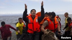 FILE - A Syrian refugee prays as he arrives on an overcrowded dinghy on the Greek island of Lesbos after crossing from the Turkish coast, September 29, 2015. 