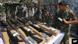 A Lebanese army soldier inspects a rifle as part of the first shipment of weapons from the U.S. to Lebanon to help bolster its military as the country faces a growing threat from Islamic militants, at the Rafik Hariri International Airport in Beirut, Lebanon, Aug. 29, 2014.