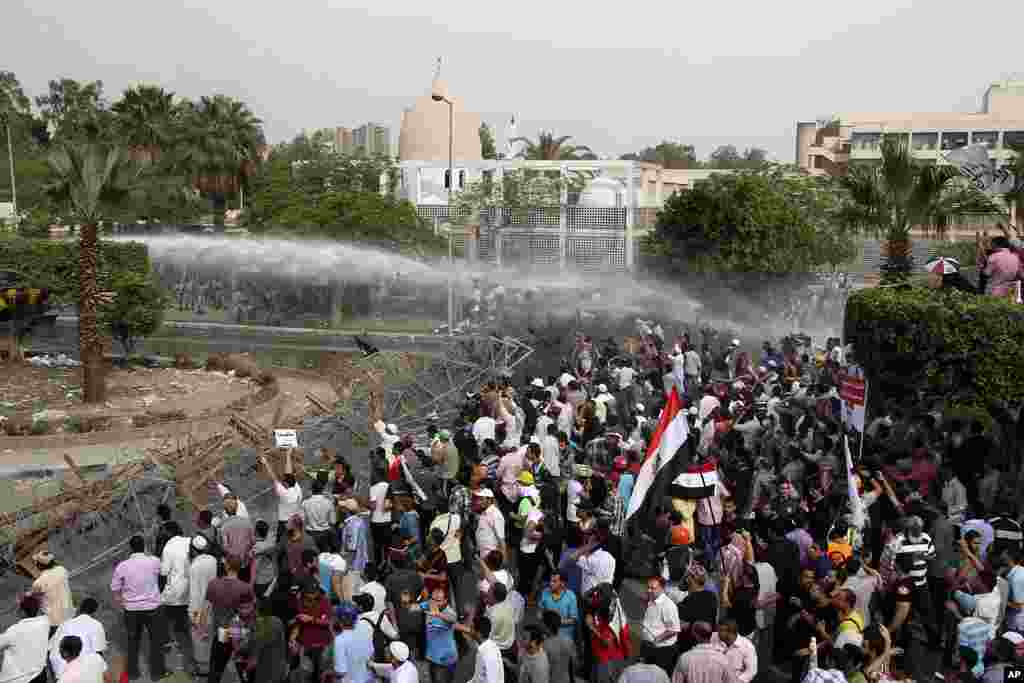 Security forces, unseen, fire a water cannon at protesters during clashes outside the Ministry of Defense in Cairo. (AP)