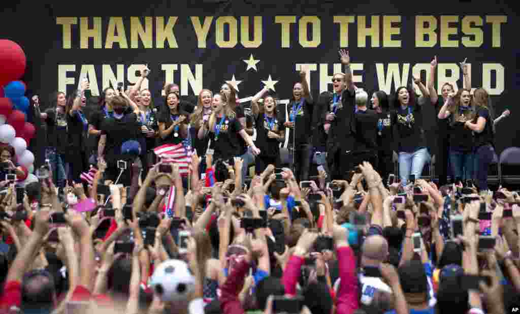 Anggota tim sepak bola putri AS dan penggemar merayakan kemenangan tim mereka dalam Piala Dunia yang baru berakhir, di Los Angeles. Ini adalah tempat pertama yang dikunjungi tim putri aS setelah mengalahkan Jepang di final Piala Dunia Putri di Kanada.