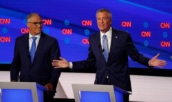 Washington Gov. Jay Inslee listens as New York City Mayor Bill de Blasio speaks during the second of two Democratic presidential primary debates hosted by CNN, July 31, 2019, in the Fox Theatre in Detroit.