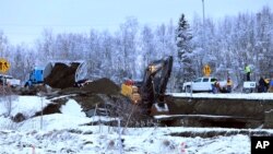 Un camión y una excavadora trabajan en una reparación temporal de una rampa que se derrumbó después del terremoto el viernes 30 de noviembre de 2018, en Anchorage, Alaska.