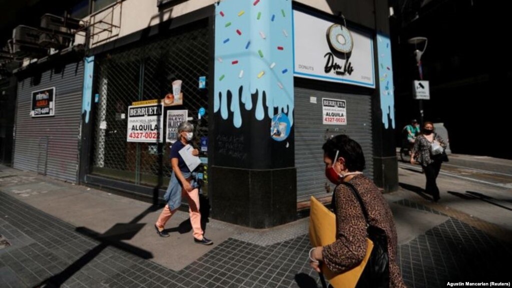 Pedestrians walk past out-of-business stores which display "For rent" signs, near the Buenos Aires' Obelisk, Argentina April 6, 2021. (REUTERS/Agustin Marcarian)