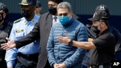 FILE - Former Honduran President Juan Orlando Hernandez is taken in handcuffs to a waiting aircraft as he is extradited to the United States, in Tegucigalpa, April 21, 2022. Hernandez was convicted in New York on March 8, 2024, of charges that he conspired with drug traffickers. 