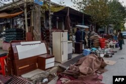 Los comerciantes afganos exhiben artículos domésticos usados para vender en un área de mercado en Kabul el 25 de agosto de 2021.