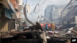 Search and rescue personnel stand in the debris caused by an explosion at the Polyplas plant in the Villas Agricolas neighborhood in Santo Domingo, Dominican Republic, Dec. 5, 2018. 