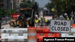 FILE - Construction workers repair a street near the White House in Washington, DC, on Aug. 10, 2021.