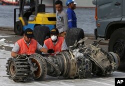 ARSIP – Para petuga memeriksa mesin pesawat yang berhasil diangkat dari lokasi jatuhnya Lion Air di Jakarta, Indonesia, 4 November 2018