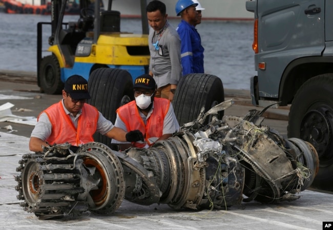 FILE - Officials inspect an engine recovered from the crashed Lion Air jet in Jakarta, Indonesia, Nov. 4, 2018. The brand new Boeing 737 MAX 8 jet plunged into the Java Sea just minutes after takeoff from Jakarta early on Oct. 29, killing all passengers on board.
