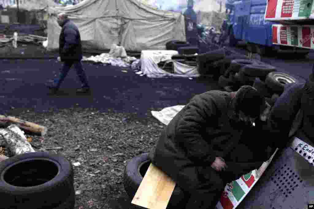 An anti-Yanukovych protester sleeps at a barricade at Independence Square, Kyiv, Feb. 28, 2014.