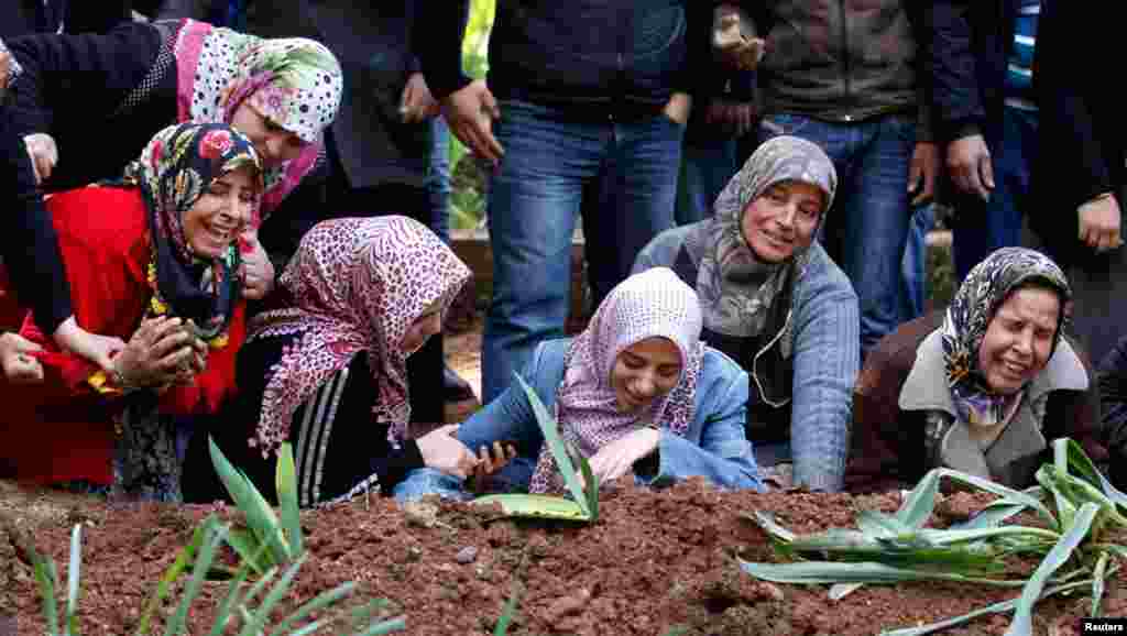 Relatives of Ali Sille, one of the 13 people killed by an explosion at a crossing on Turkey&#39;s border with Syria, mourn at his grave in the town of Reyhanli, Turkey, February 12, 2013. 