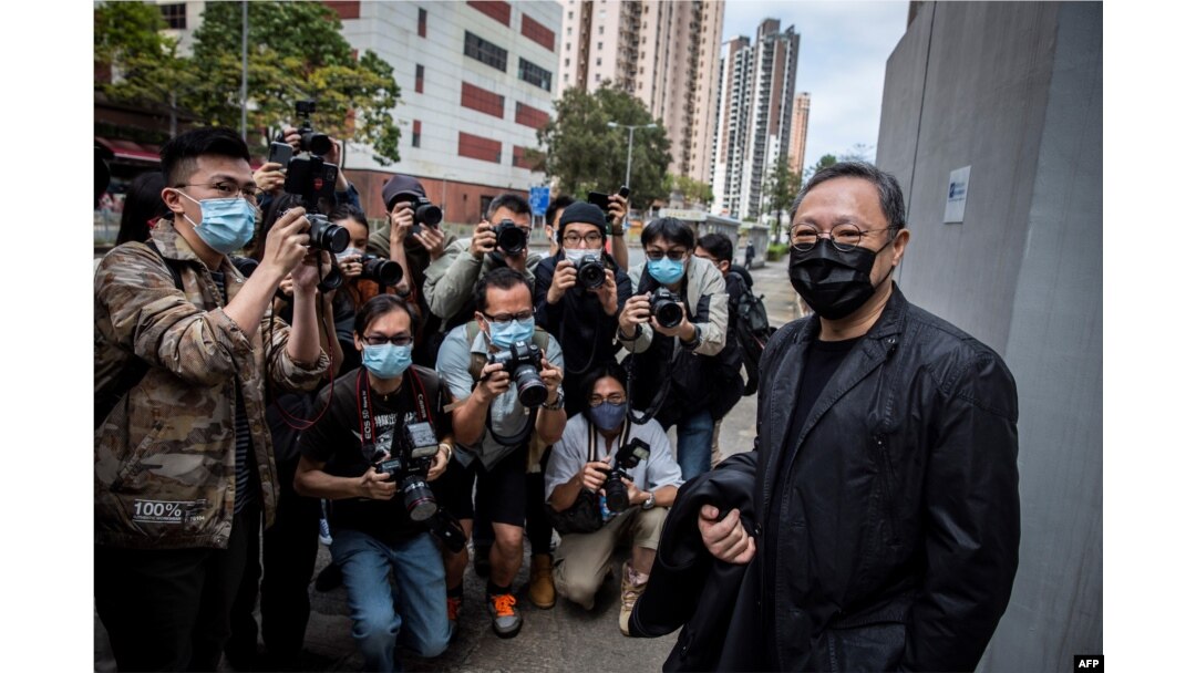 Profesor hukum Hong Kong dan aktivis pro-demokrasi Benny Tai (kanan) tiba di kantor polisi Ma On Shan di Hong Kong pada 28 Februari 2021. (Foto: AFP)