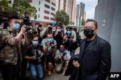 Profesor hukum Hong Kong dan aktivis pro-demokrasi Benny Tai (kanan) tiba di kantor polisi Ma On Shan di Hong Kong pada 28 Februari 2021. (Foto: AFP)