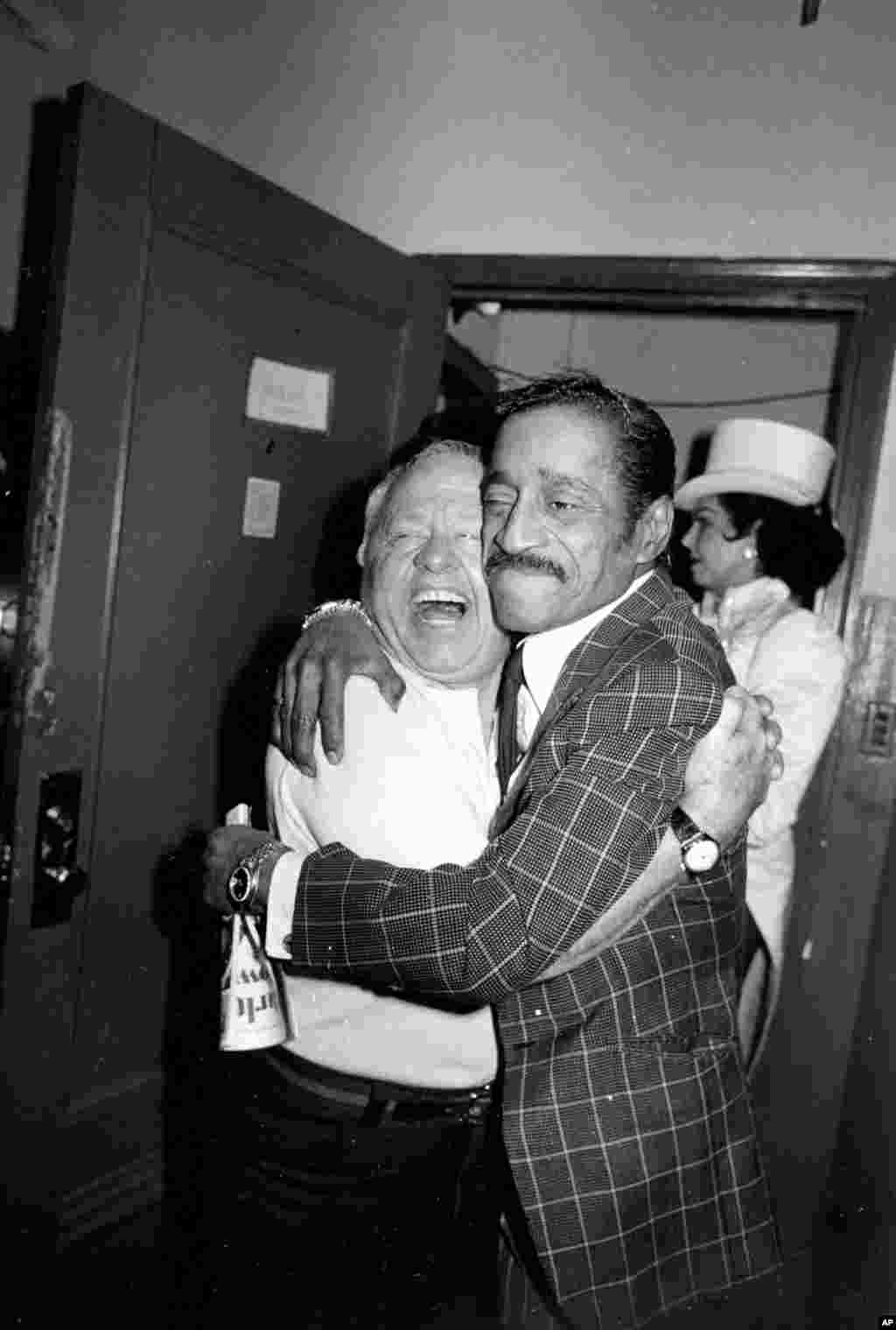 Actor Mickey Rooney, left, gets a hug from entertainer Sammy Davis, Jr. backstage during intermission at New York&#39;s Mark Hellinger Theater where Rooney is appearing in the Broadway musical comedy revue &quot;Sugar Babies,&quot; April 6, 1981.&nbsp;