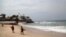 FILE - Surfers walk along a beach in Mazatlan, state of Sinaloa, Mexico.
