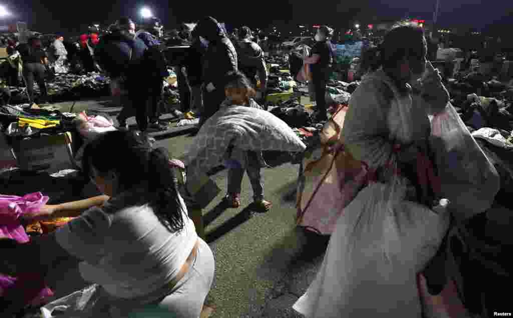 People affected by the Eaton Fire pick up supplies and clothing at a distribution center at Santa Anita Park in Arcadia, California, Jan. 11, 2025. 