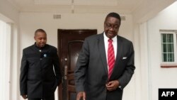 Peter Mutharika, candidat du Parti démocrate-progressiste (DPP) du Malawi aux élections présidentielles, quitte sa maison flanquée de son compatriote Saulos Chilima, à Blantyre, le 25 mai 2014.