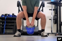 Jacob Bullard lifts a weight as part of his physical therapy at WashU, Monday, Dec. 16, 2024, in St. Louis. (AP Photo/Jeff Roberson)