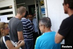 People wait in line outside of a currency exchange house in Caracas, Venezuela, Feb. 5, 2019.