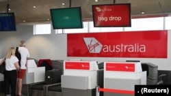 Wisatawan berdiri di loket Virgin Australia Airlines di Bandara Internasional Kingsford Smith, setelah wabah virus korona, di Sydney, Australia, 18 Maret 2020. (Foto: REUTERS/Loren Elliott)