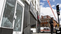 Smashed glass doors and windows and wrecked shutters of a betting shop and a jewelry shop in Enfield, north London, Aug. 8, 2011