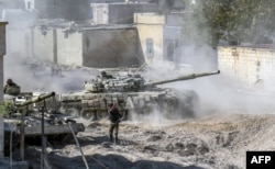 A Syrian Army modified T-72 tank drives during Syrian forces' assault to capture the rebel-held village of Hawsh Nasri, which is located near the rebel-held town of Douma on the eastern outskirts of the capital Damascus, Nov. 22, 2016.