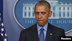 U.S. President Barack Obama (R) delivers remarks in reaction to the shooting deaths of nine people at an African-American church in Charleston, South Carolina, from the podium in the press briefing room of the White House in Washington, June 18, 2015. 