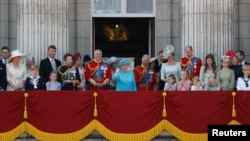 Britain's Queen Elizabeth, Prince Charles, Prince Harry and Meghan, Duchess of Sussex, Prince William and Catherine, Duchess of Cambridge, along with other members of the British royal family, wave from the balcony of Buckingham Palace as part of Trooping