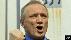 Former presidential candidate Vladimir Neklyaev gestures as he speaks to the media after leaving a court building in Minsk, Belarus, May 20, 2011