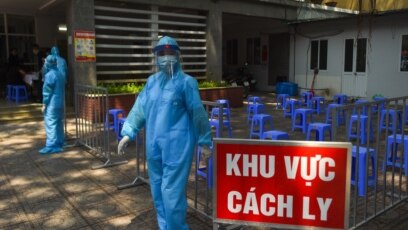 Nhân viên y tế trong trang phục bảo hộ chờ người dân đến một địa điểm xét nghiệm nhanh COVID-19 ở Hà Nội, ngày 30 tháng 7, 2020.